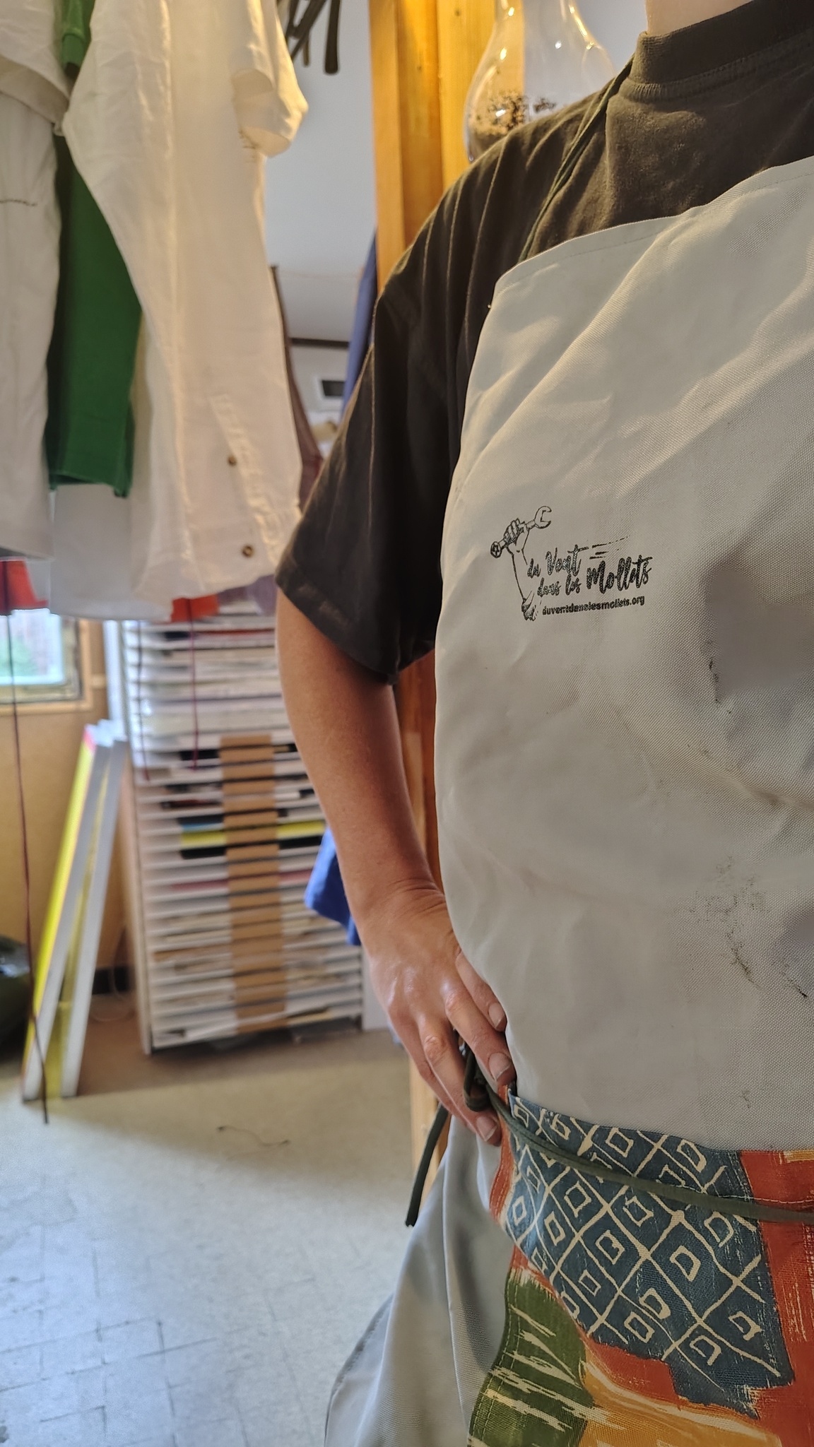 une personne en tablier dans un atelier de serigraphie